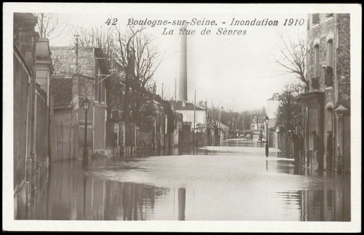 42 - Boulogne-sur-Seine - Inondations 1910 - La rue de Sèvres, Boulogne-Billancourt. rue de Sèvres . - Crue de la Seine, janvier 1910Vue sur la rue de Sèvres inondée. A droite, des habitants regardent la scène. Au fond, une cheminée.