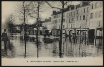 9 - Boulogne Inondé - Janvier 1910 - Grande-Rue, Boulogne-Billancourt. avenue Jean-Baptiste Clément . - Crue de la Seine, janvier 1910L'avenue inondée. Au premier plan, à gauche, un homme. Au centre, une hippomobile et sur le trottoir de droite des commerces : Hôtel de Bellevue, Epicerie Centrale Boulogne (Maison A. Lamotte), cycles