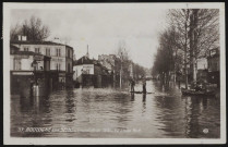 Boulogne-sur-Seine - Inondation 1910 - Grande-Rue, Boulogne-Billancourt . avenue Jean-Baptiste Clément . - Crue de la Seine, janvier 1910 - l'avenue Jean-Baptiste Clément inondée. A gauche, un café "La civette du rond point", une pâtisserie et une boulangerie. Au premier plan, au centre et à droite des personnes sur des embarcations. Au fond, un groupe regarde la scène.