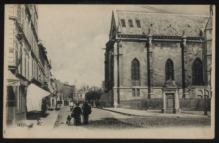 Boulogne-sur-Seine. - La rue de l'Eglise. Deux femmes et un enfant dans la rue, un homme marche devant eux. A gauche, deux chiens sur le trottoir.