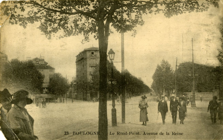 23 - Boulogne. Le Rond-Point. Avenue de la Reine, Boulogne-Billancourt . avenue de la Reine, rond-point Rhin-et-Danube . - PerspectiveAu premier plan à gauche, un homme et une femme portant des chapeaux. A droite, un groupe d'homme et de femmes . Au second plan, le rond-point Rhin et Danube puis l'avenue de la Reine.