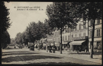 49 - Boulogne-sur-Seine, Avenue J.-B. Clément, Boulogne-Billancourt . avenue Jean-Baptiste Clément . - perspectiveA gauche, l'avenue et ses rails pour tramways. A droite, le trottoir avec des pompes à essence et des commerces : Maison Sionneau (une publicité sur la façade "Persil lave tout tout seul"), Seflex, Café Massenet, Hôtel Bellevue