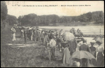 627 - Les Bords de la Seine à Billancourt - Match Basse-Seine contre Marne, Boulogne-Billancourt . Billancourt; bords de Seine . - match d'avironSpectateurs de dos, au bord de la Seine. A droite, des athlètes mettent une embarcation à l'eau.