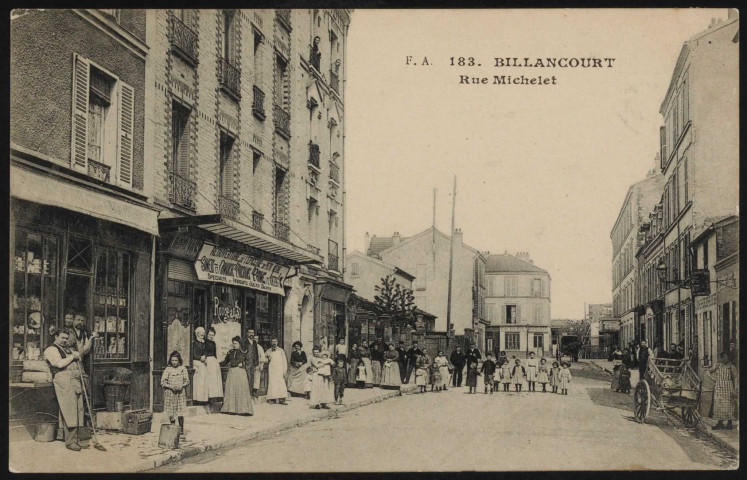 183 - Billancourt - Rue Michelet, Boulogne-Billancourt . rue Michelet . - perspectiveUn groupe de personnes (hommes, femmes et enfants) posent dans la rue de Meudon.Au premier plan, à gauche, un marchand de vins et liqueurs et "l'épicerie du Petit Nègre".A droite, un commerce de ressemelage. Au second plan, "la laiterie Normande".