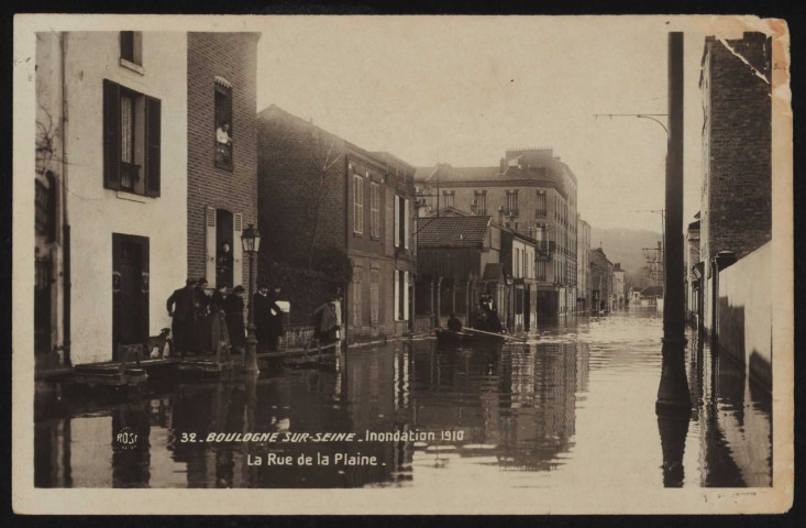 32 - Boulogne-sur-Seine - Inondation 1910 - La Rue de la Plaine, Boulogne-Billancourt. rue de Galliéni . - Crue de la Seine, janvier 1910 - Vue sur la rue de Galliéni (tronçon entre la rue de Sèvres et le quai Alphonse Le Gallo) inondée. Au premier plan, à gauche, des individus circulent sur les passerelles de fortune. Au second plan, au centre, une embarcation