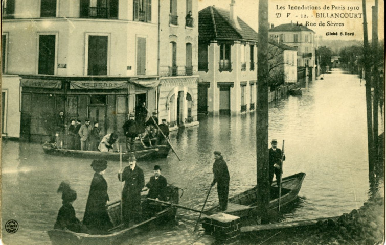 Les inondations de Paris 1910 - 12 - Billancourt - La rue de Sèvres, Boulogne-Billancourt. rue de Sèvres . - Crue de la Seine, janvier 1910perspective sur la rue de Sèvres, depuis l'angle de la rue Galliéni, inondée par la crue de la Seine.Au premier plan, on peut voir 3 embarcations. A gauche, la maison Dedon.