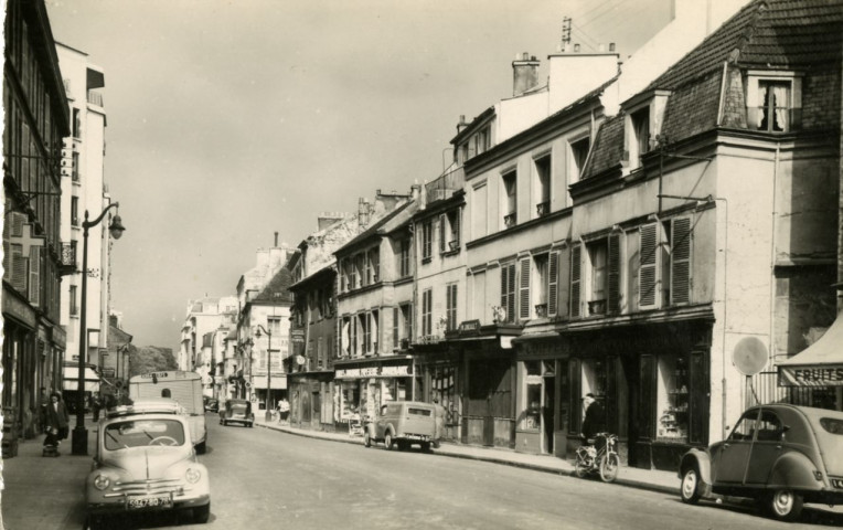 50 - Boulogne (Seine) - Avenue J.-B. Clément, Boulogne-Billancourt . avenue Jean-Baptiste Clément . - perspective - Scène de rue. A gauche, une pharmacie et une Renault 4L. A droite, une Citroën 2CV et des commerces : "produits français et étrangers" au numéro 37, le coiffeur Forvil, un marchand de journaux.